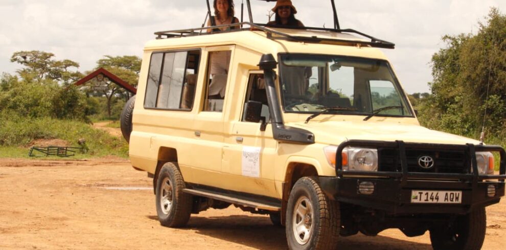 Safari jeep with travelers enjoying wildlife viewing in Tanzania